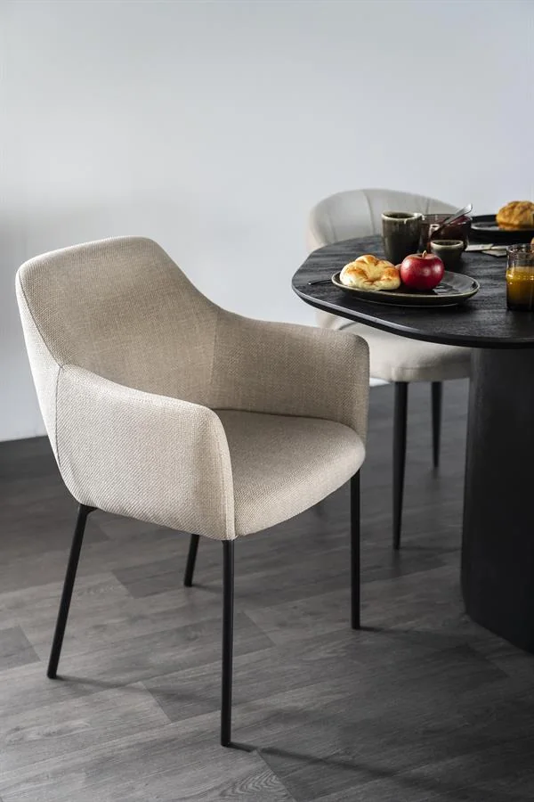 Beige eetkamerstoel met armleuningen aan een ovale zwarte tafel